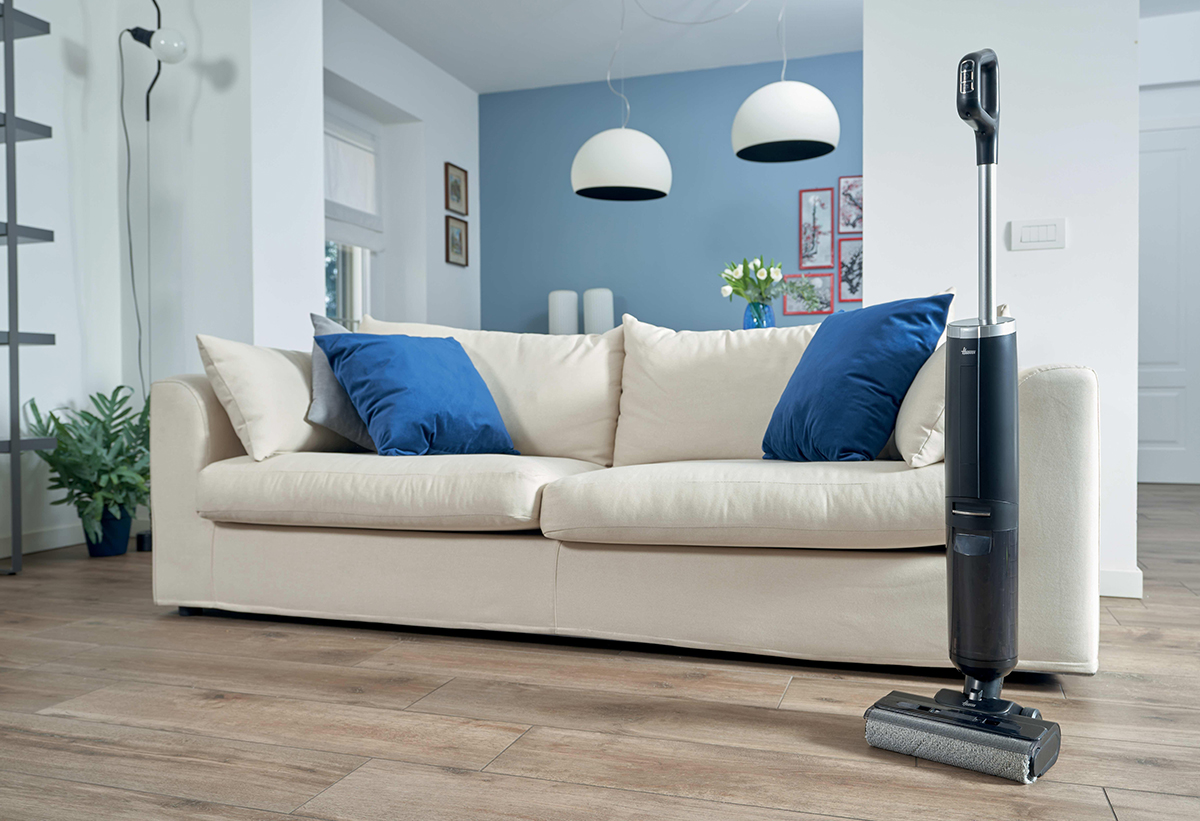 Απεικονίζεται η σκούπα όρθια σε σαλόνι.